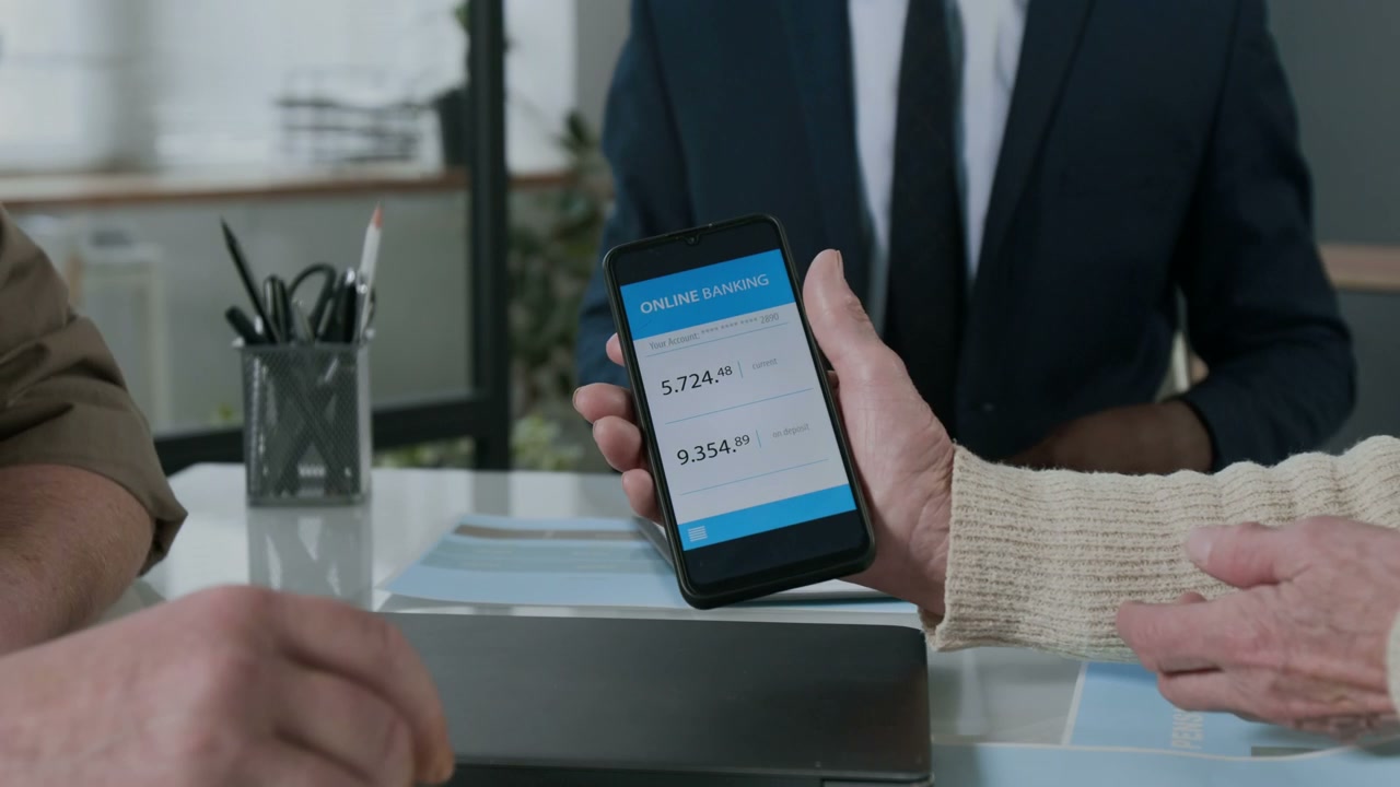 Hands Using Mobile Banking App in Office