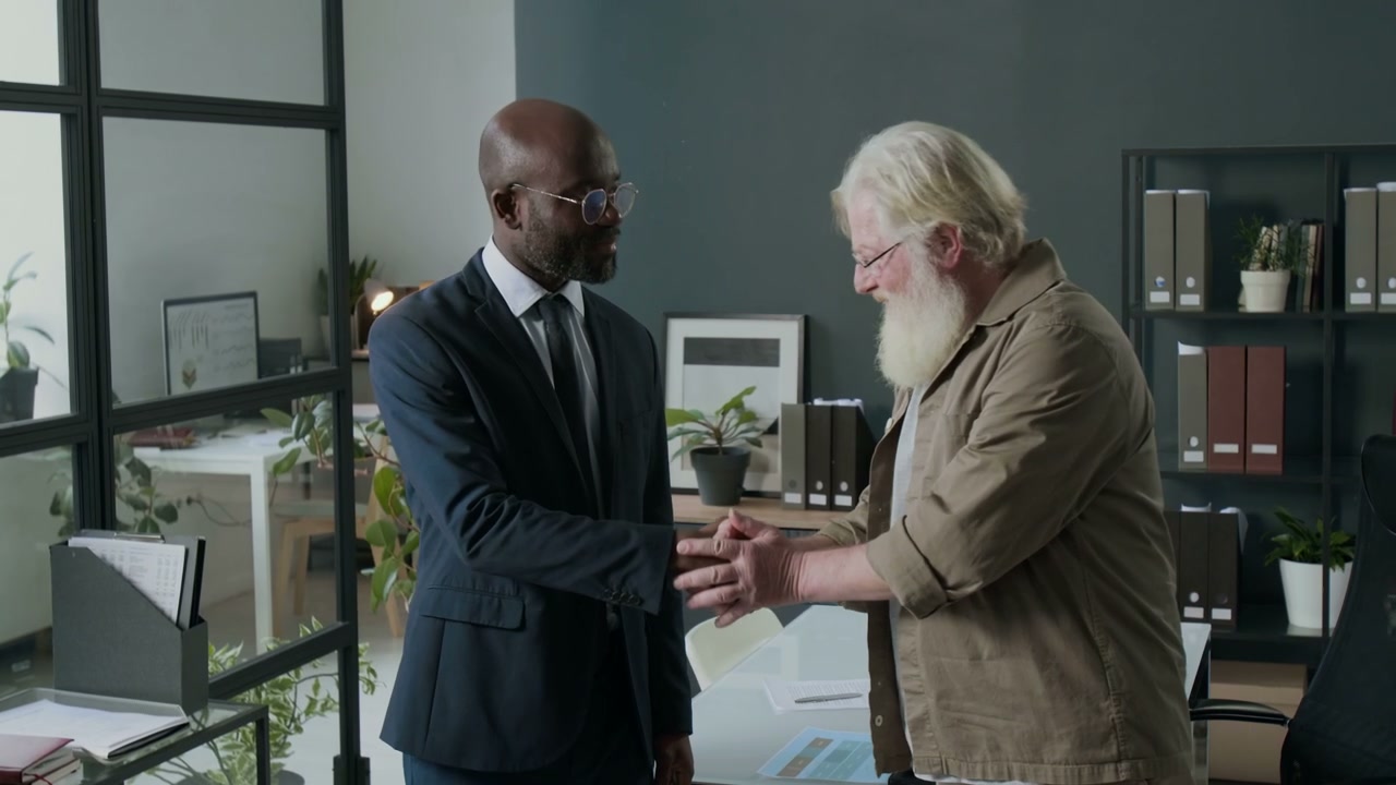 Two Businessmen Shake Hands in Office