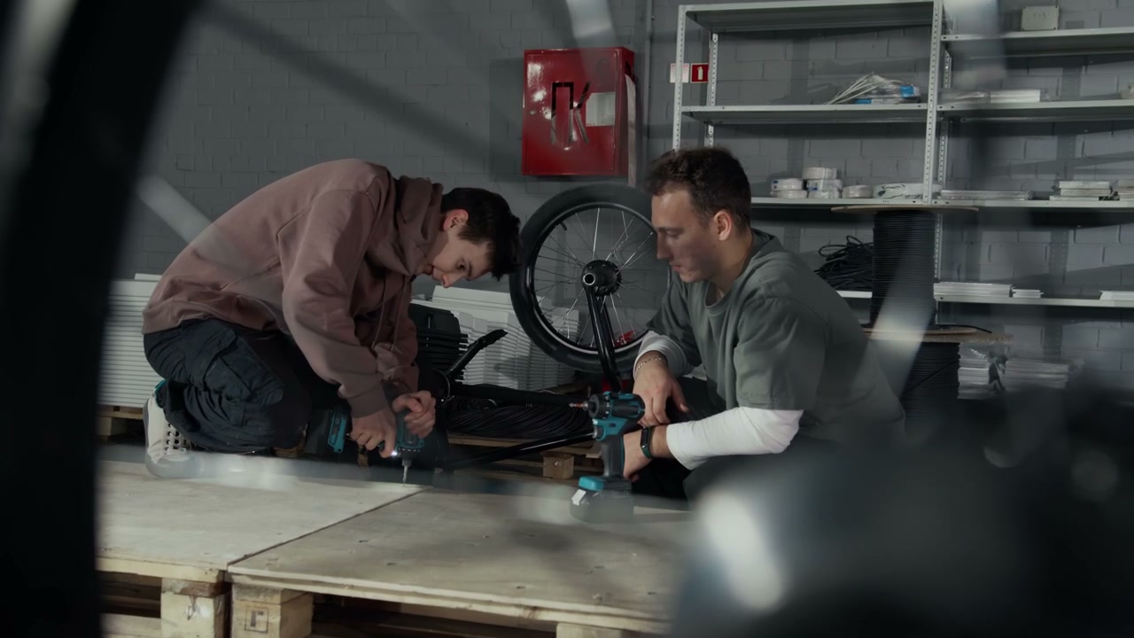 Two Men Assembling BMX Bike in Hangar