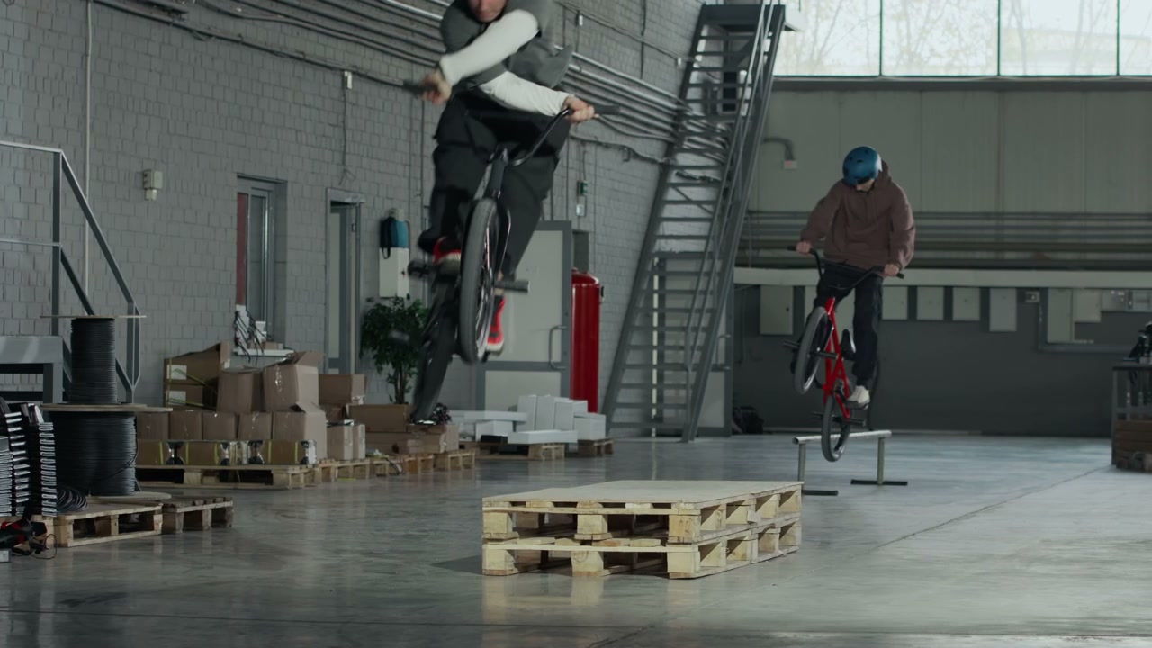 BMX Riders Performing Stunts in Hangar
