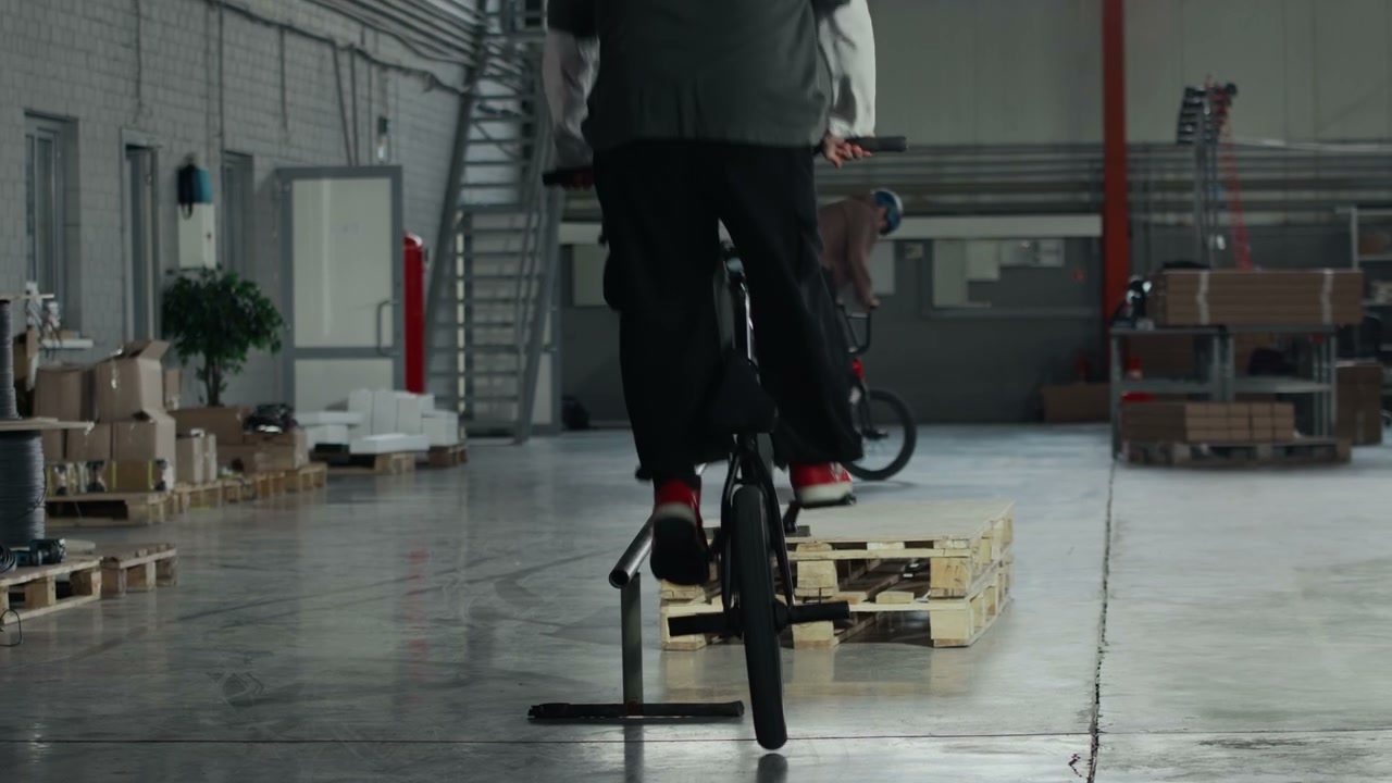 BMX Rider Grinding Rail in Warehouse