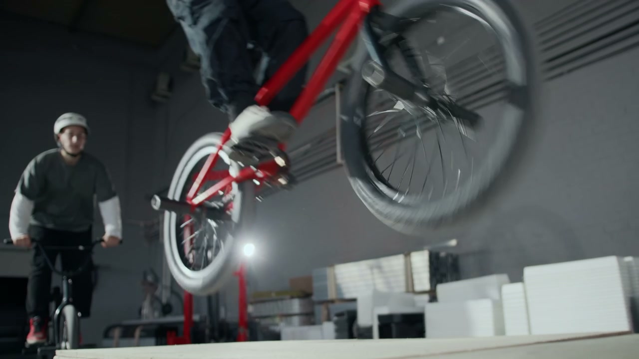 BMX Riders Jumping Pallets in Hangar