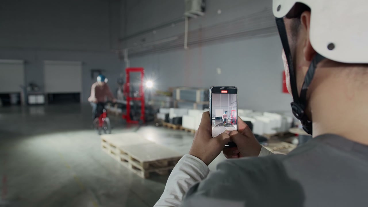 Person Films BMX Rider Performing Stunt in Warehouse