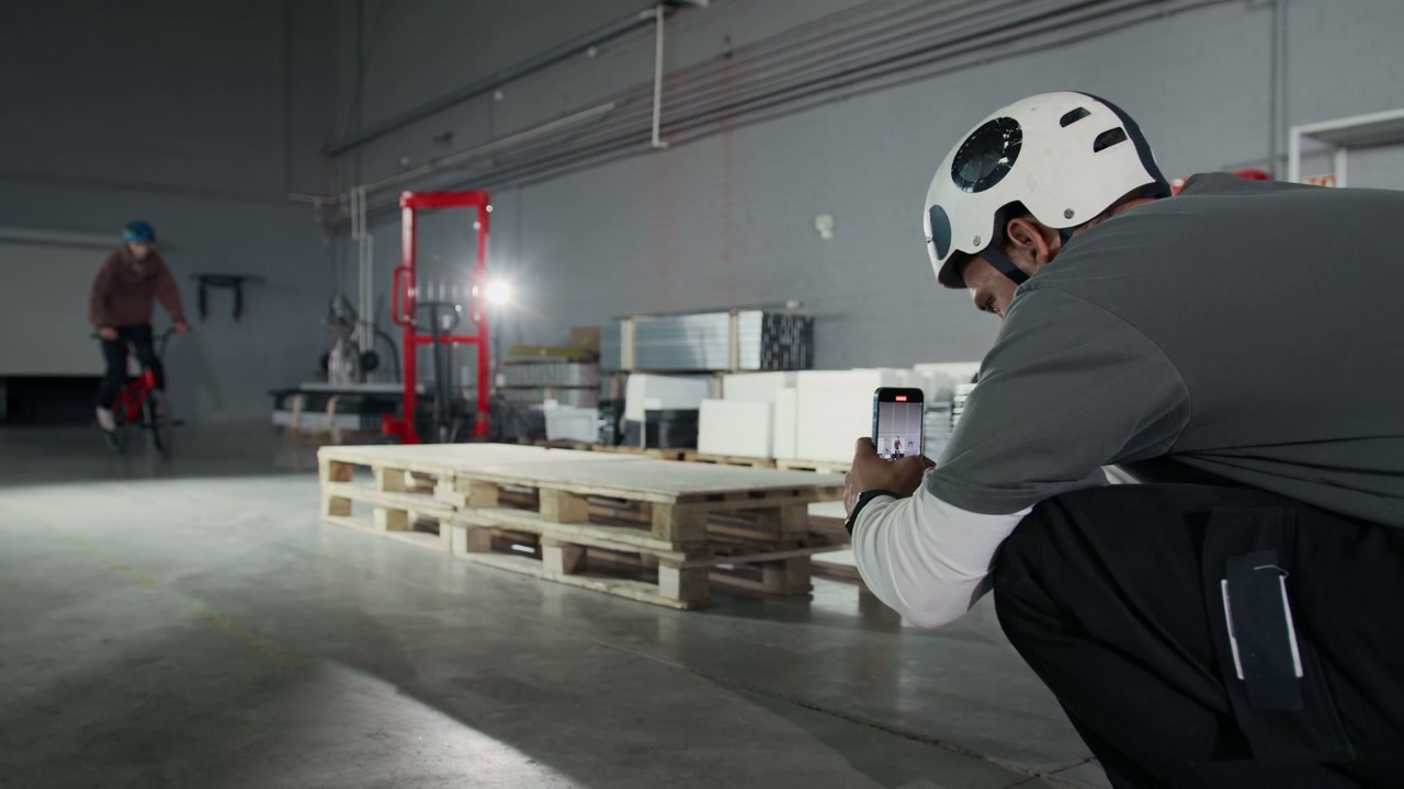 BMX Rider Jumps Pallets in Warehouse