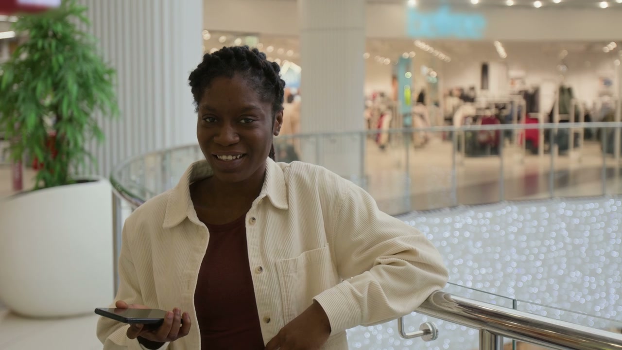 Young Black Woman Smiling in Shopping Mall