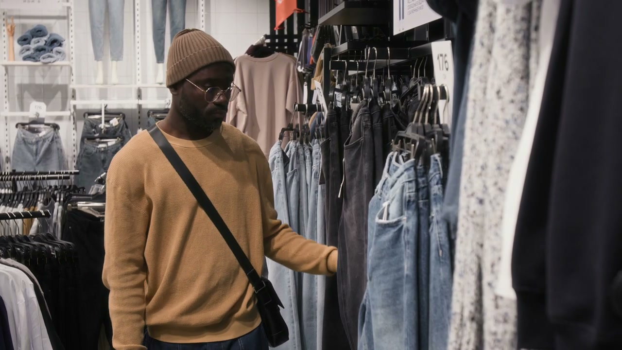 Black Man Browsing Jeans in Clothing Store