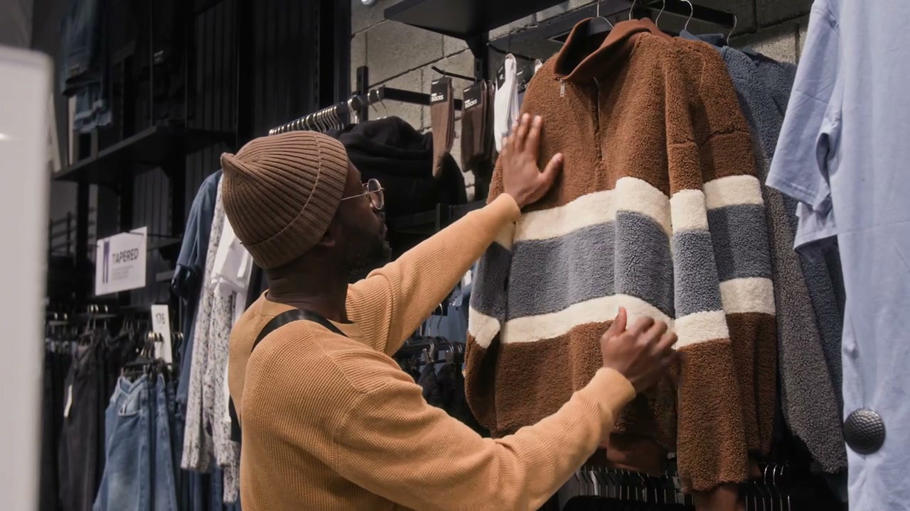 Man Shopping for a Sweater in a Clothing Store