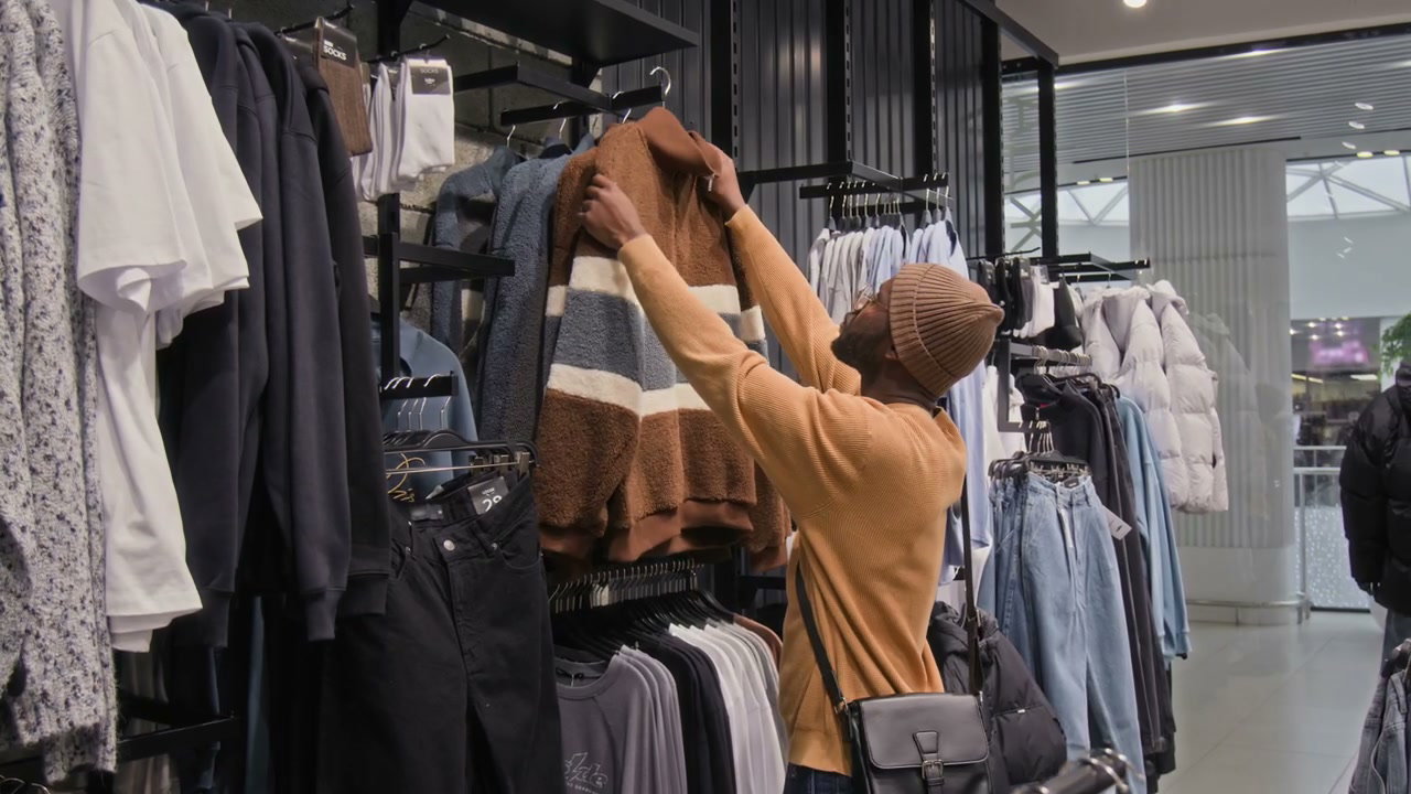 Man Shopping for Sweater in Clothing Store