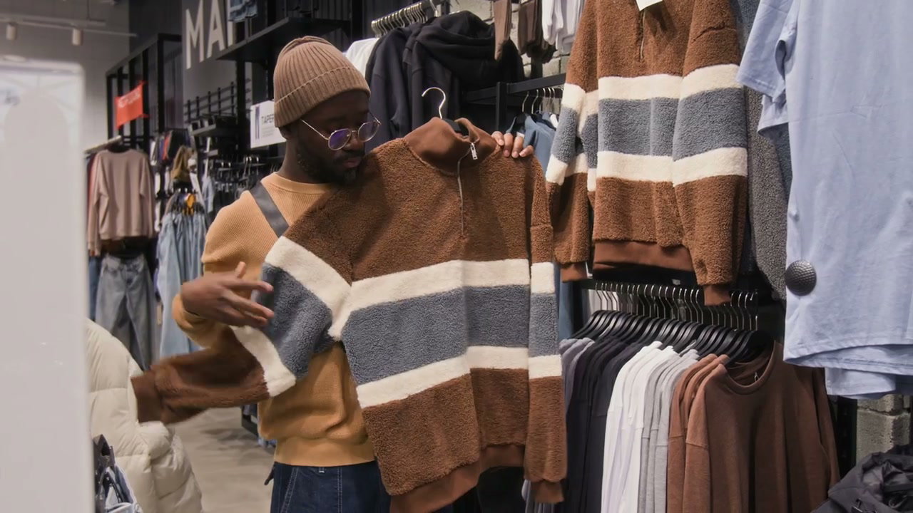 Man Shopping for a Sweater in a Clothing Store