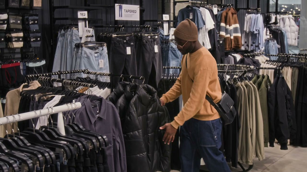 Man Browsing Jackets in Clothing Store
