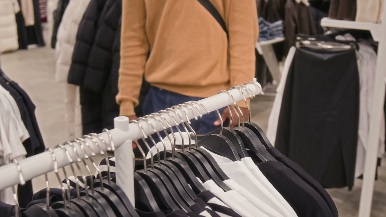 Customer Browsing T-Shirts in Clothing Store