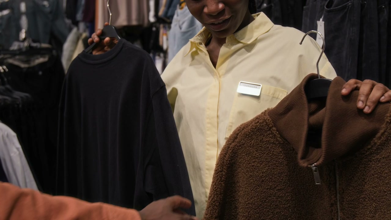 Sales Assistant Helps Man Choose Sweater