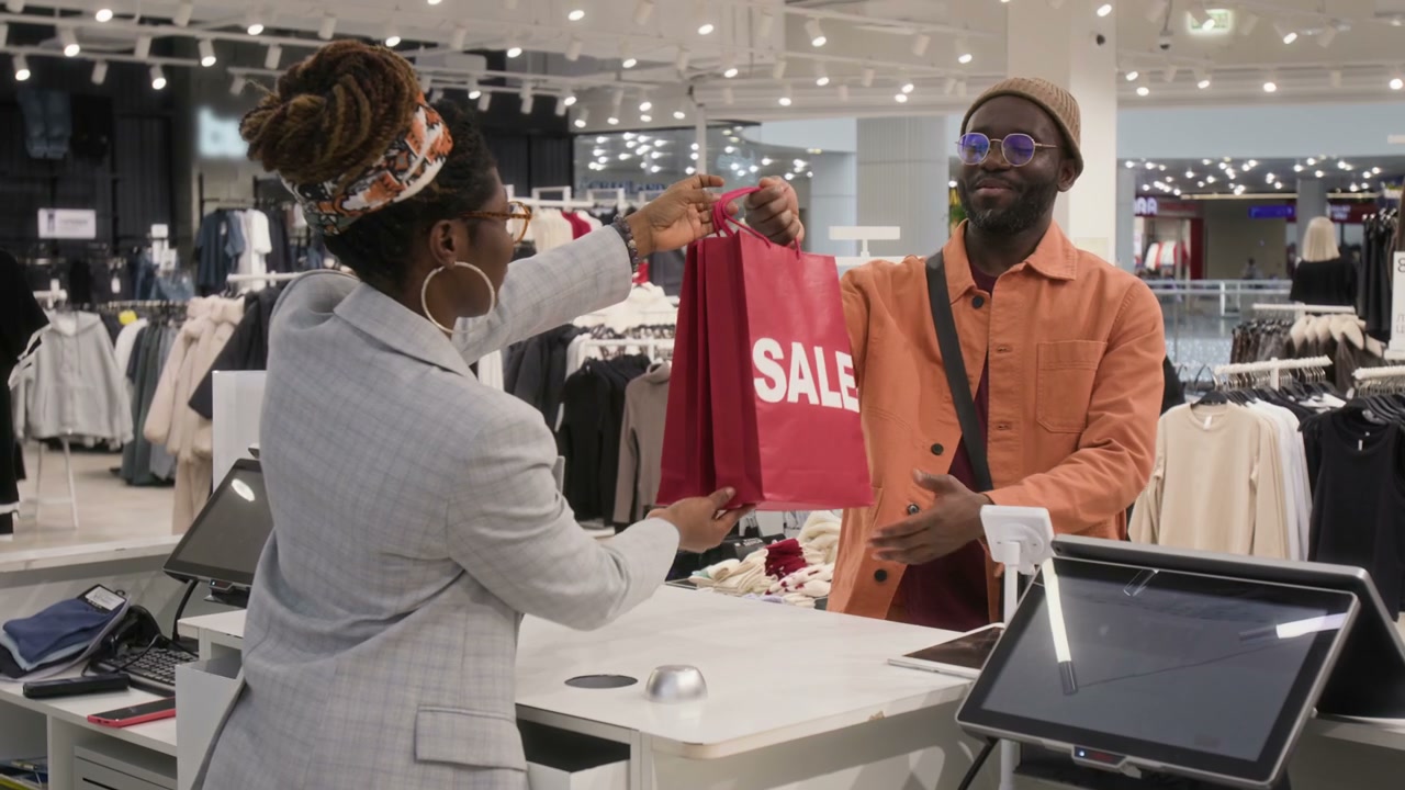 Sales Assistant Hands Customer Sale Bag