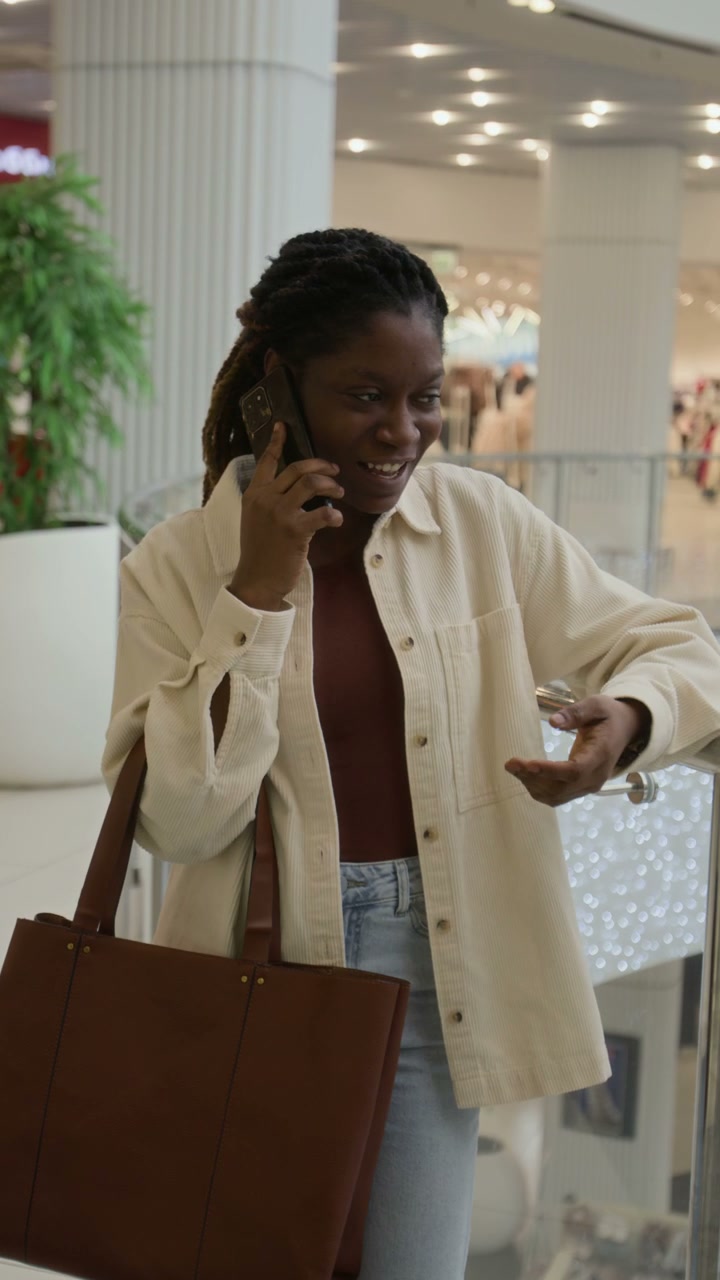 Smiling Woman Talking on Phone in Mall