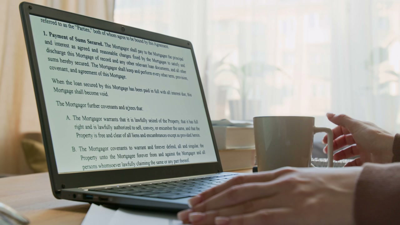 Reviewing Mortgage Agreement on Laptop