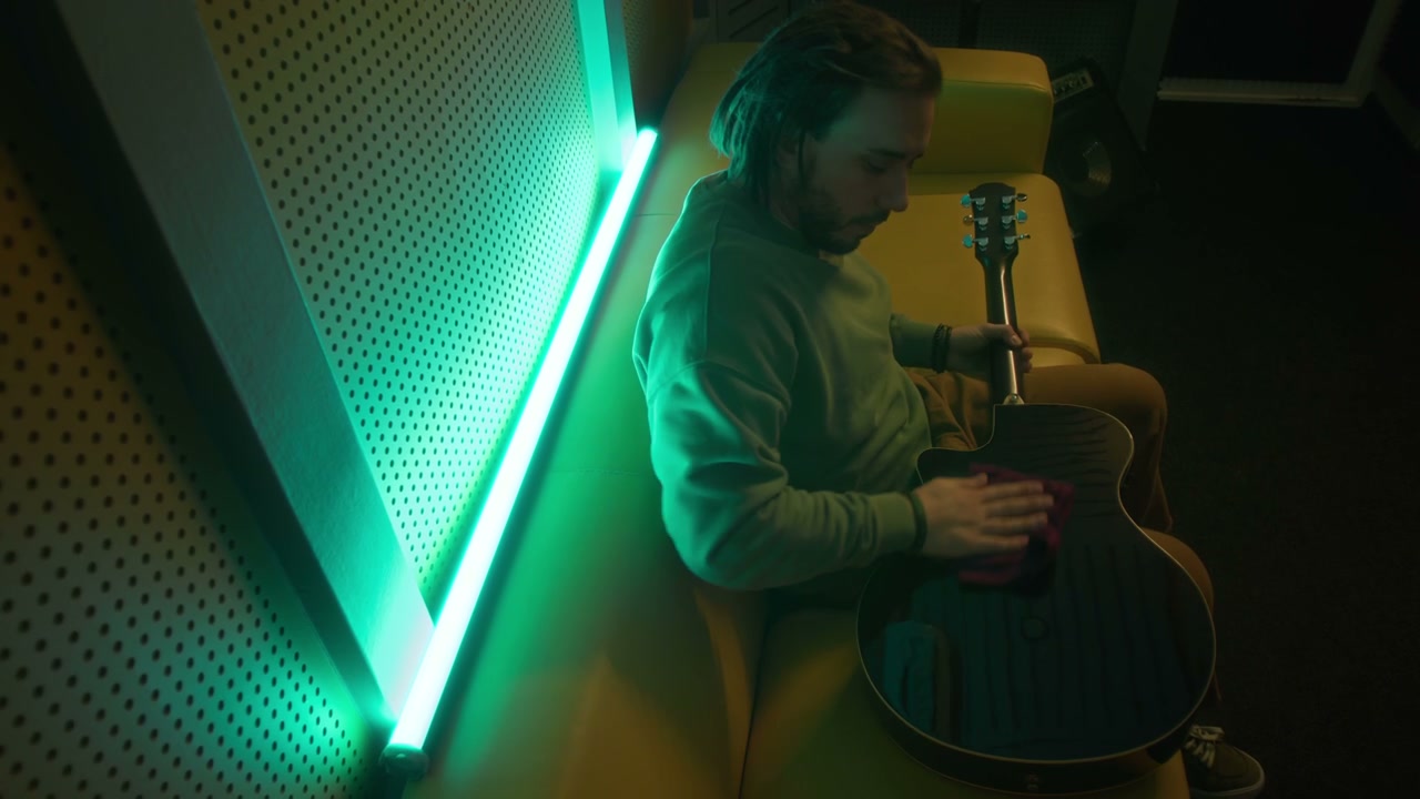 Musician Cleaning Acoustic Guitar in Studio