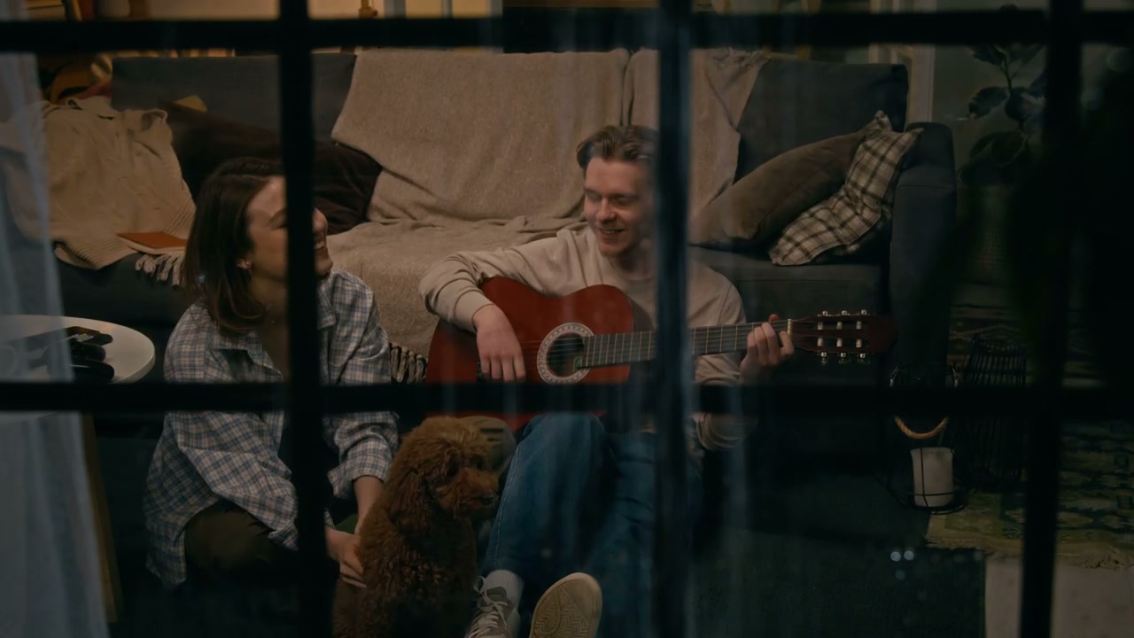 Through Window: Couple Playing Guitar and Laughing