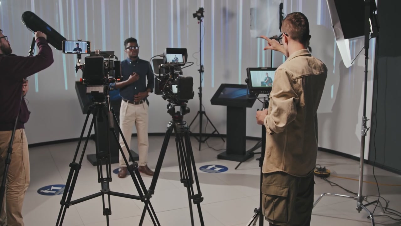 Video Production Team Filming Presenter in Studio