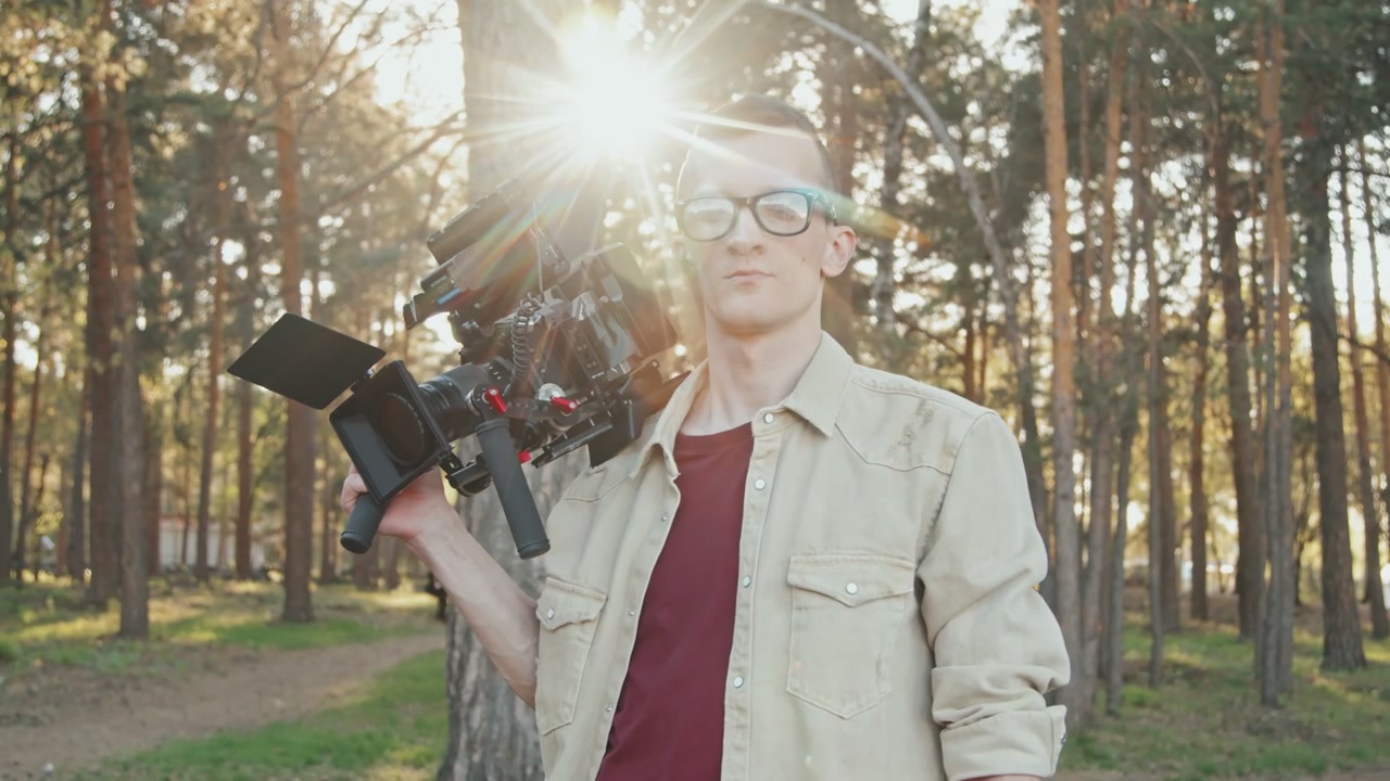 Videographer with Camera Rig in Sunny Forest