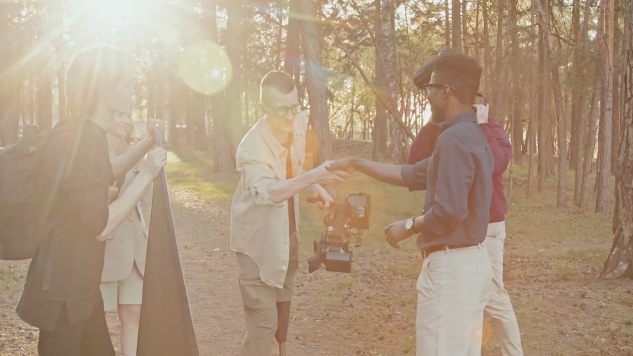 Diverse Film Crew High-Fiving Outdoors
