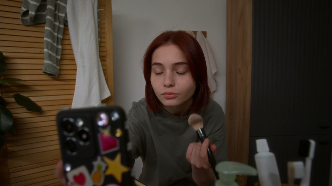 Teenage Girl Applying Makeup with Smartphone