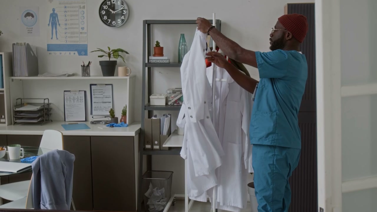 Doctor Puts on Lab Coat in Break Room