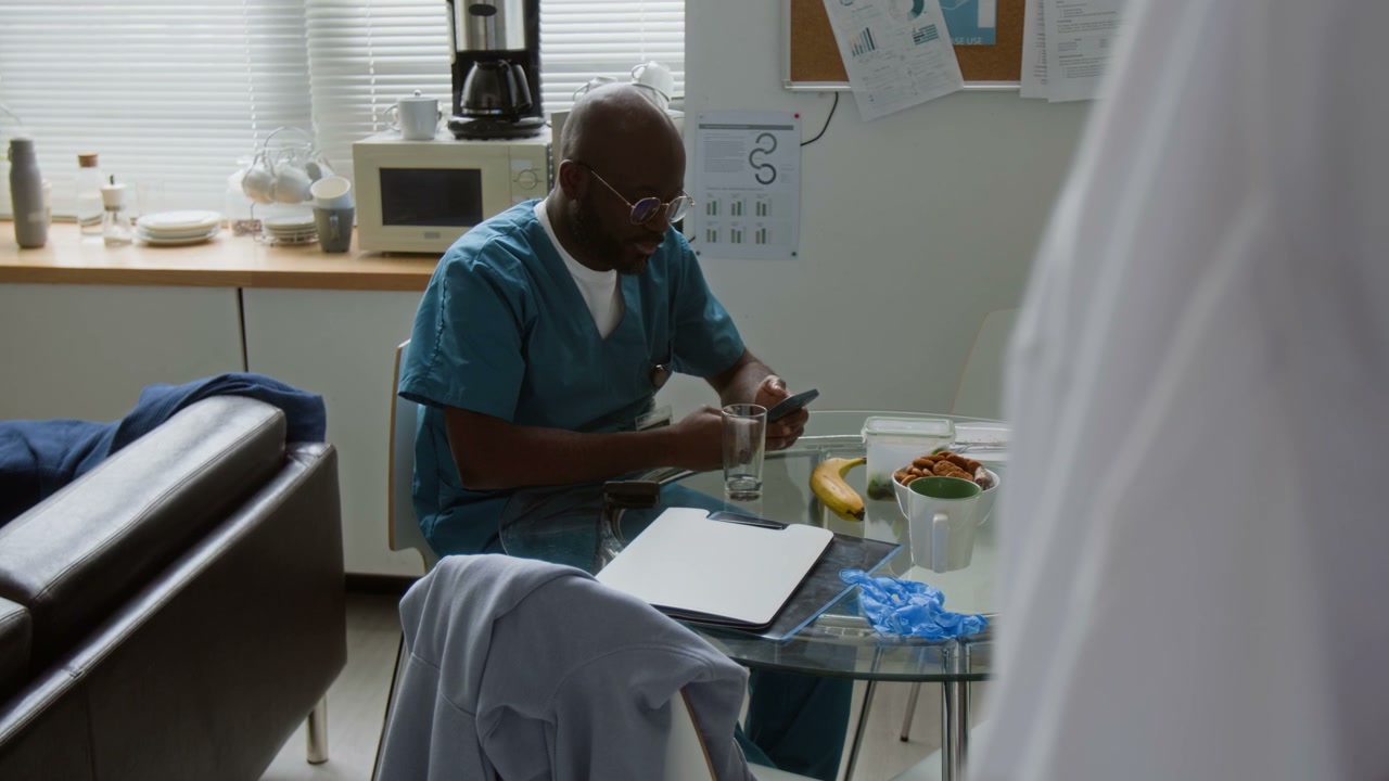 Doctor Using Smartphone in Break Room