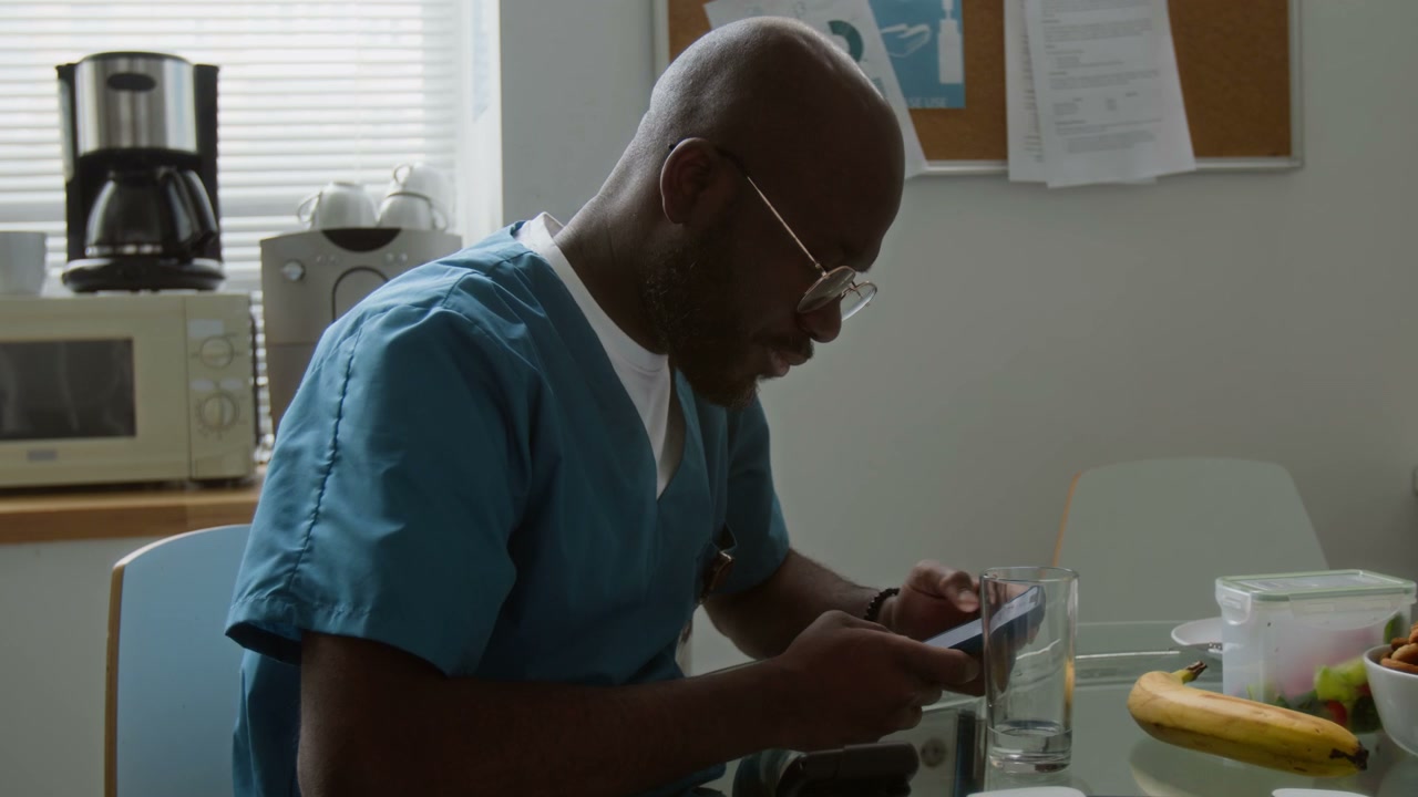 Doctor Relaxing and Using Smartphone in Break Room