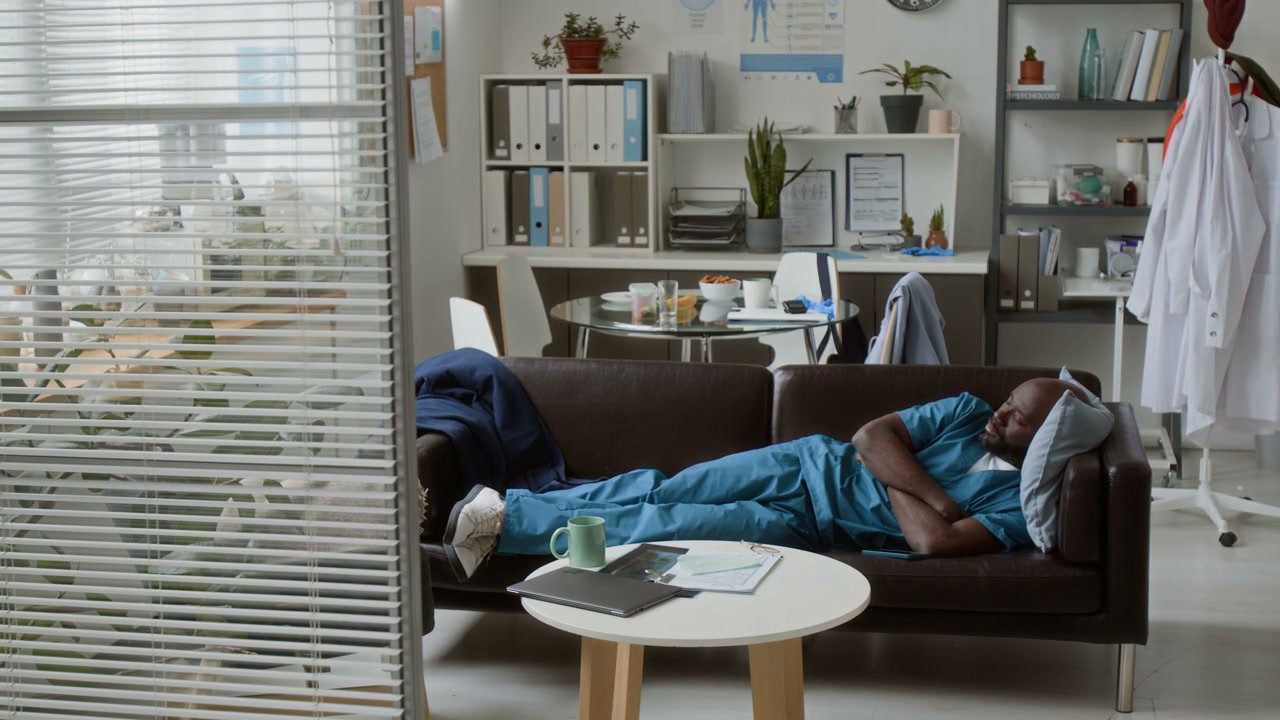 Doctor Napping On Couch In Break Room