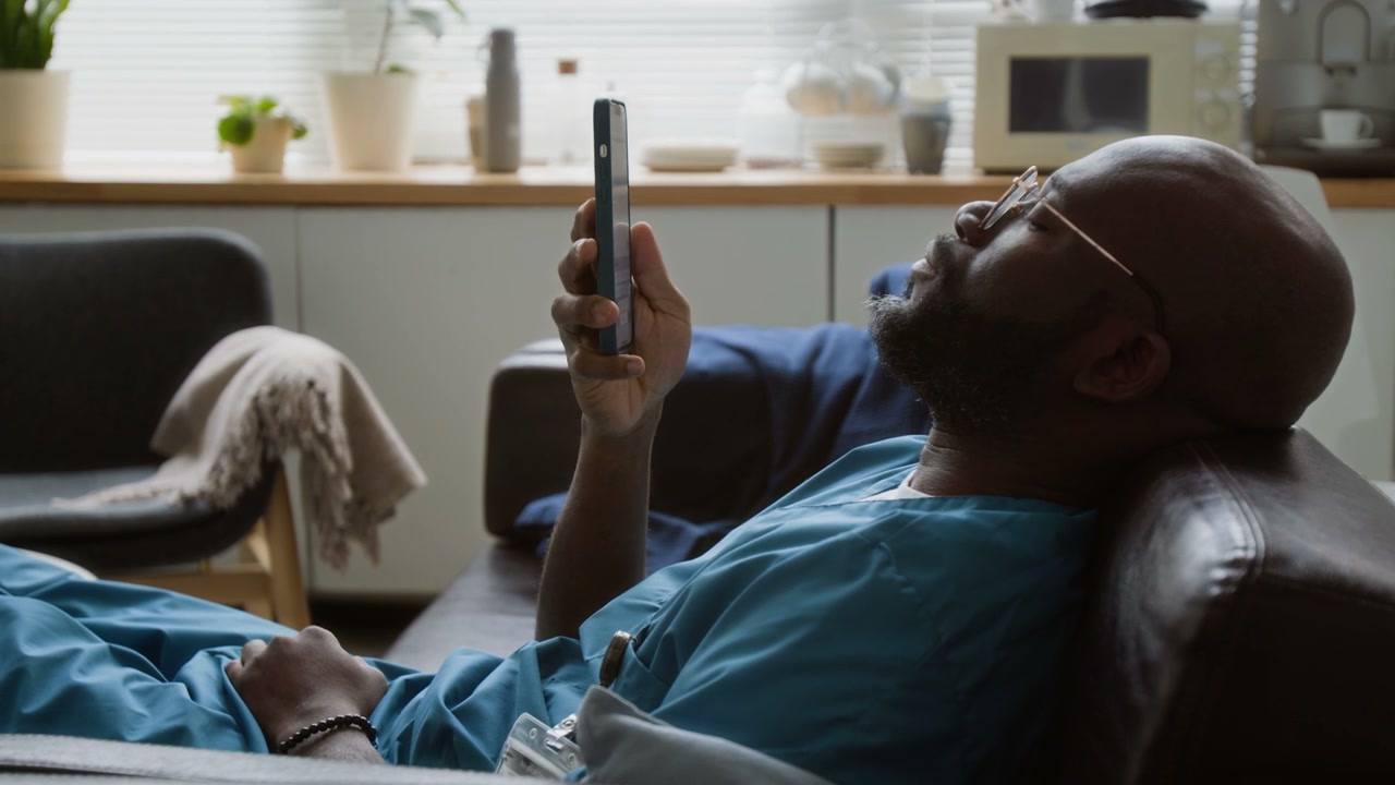 Tired Doctor on Break Using Smartphone