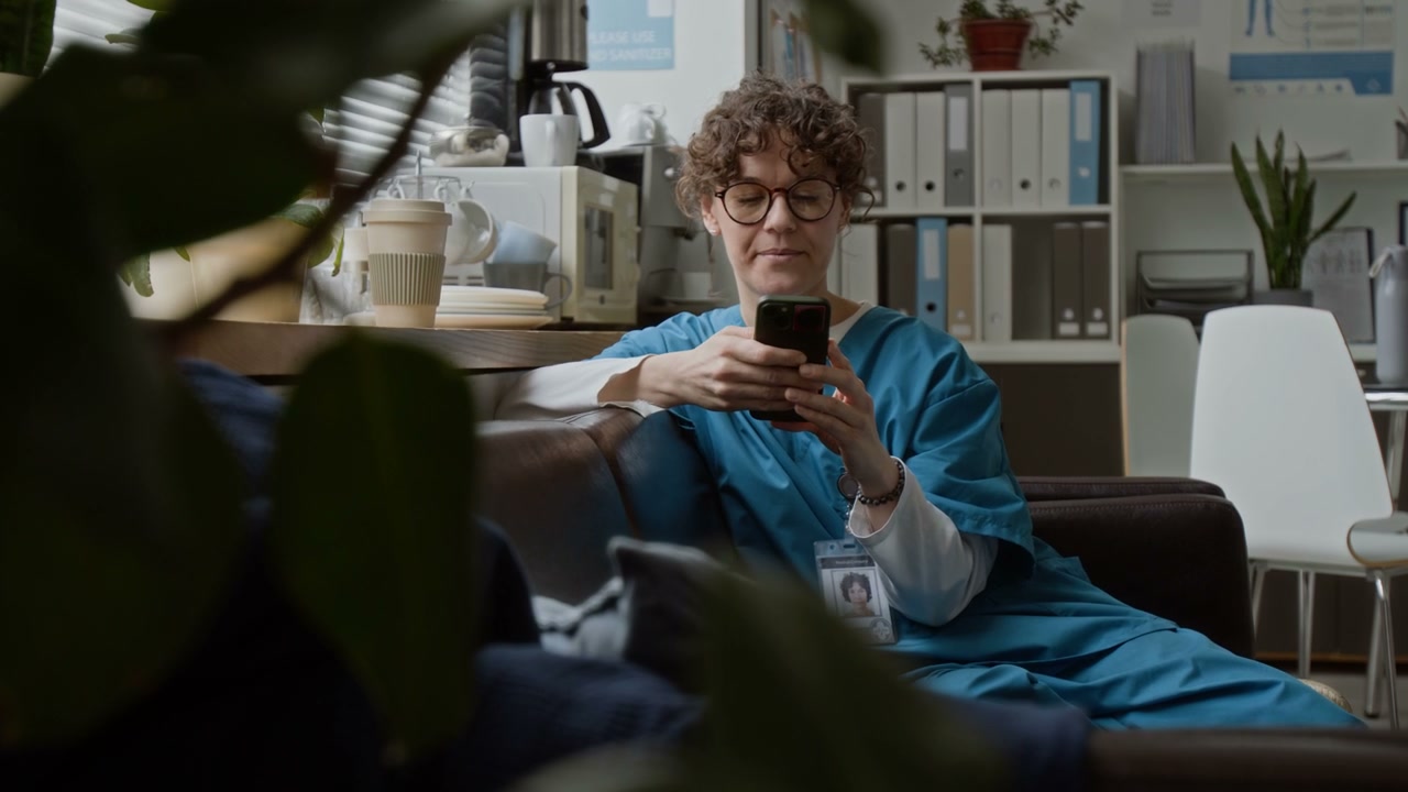 Female Doctor Resting With Phone in Break Room