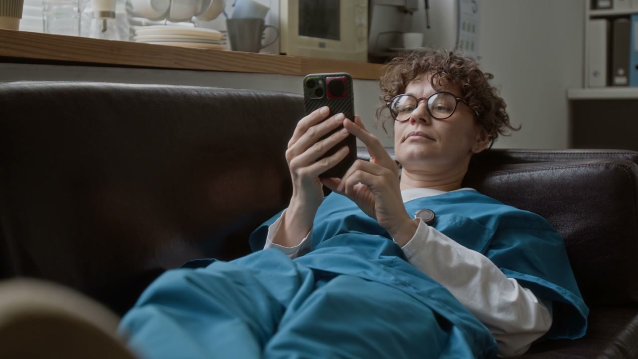 Healthcare Worker Using Smartphone in Break Room