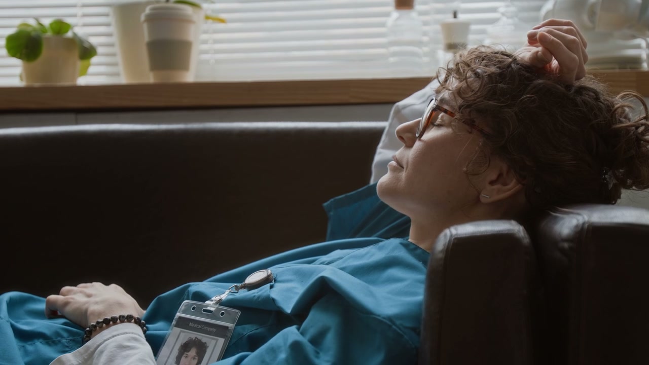 Doctor Resting on Sofa in Break Room