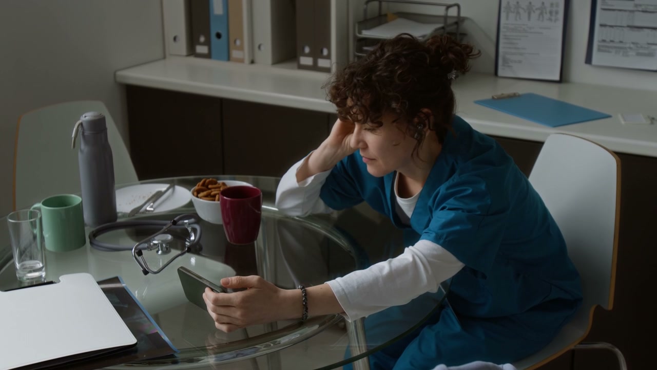 Doctor Scrolling on Smartphone During Break