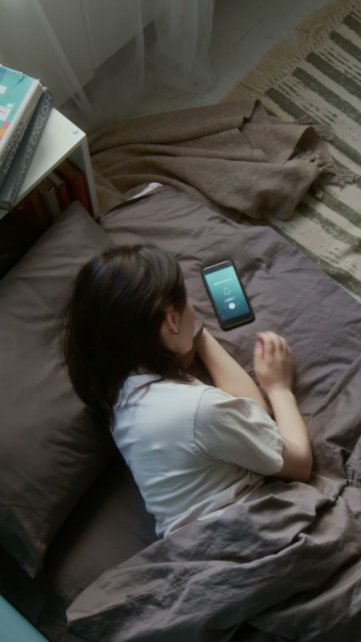 Young Person Hitting Snooze in Bed