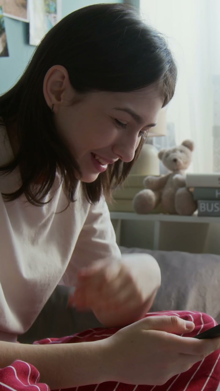 Teenager Laughing While Using Phone