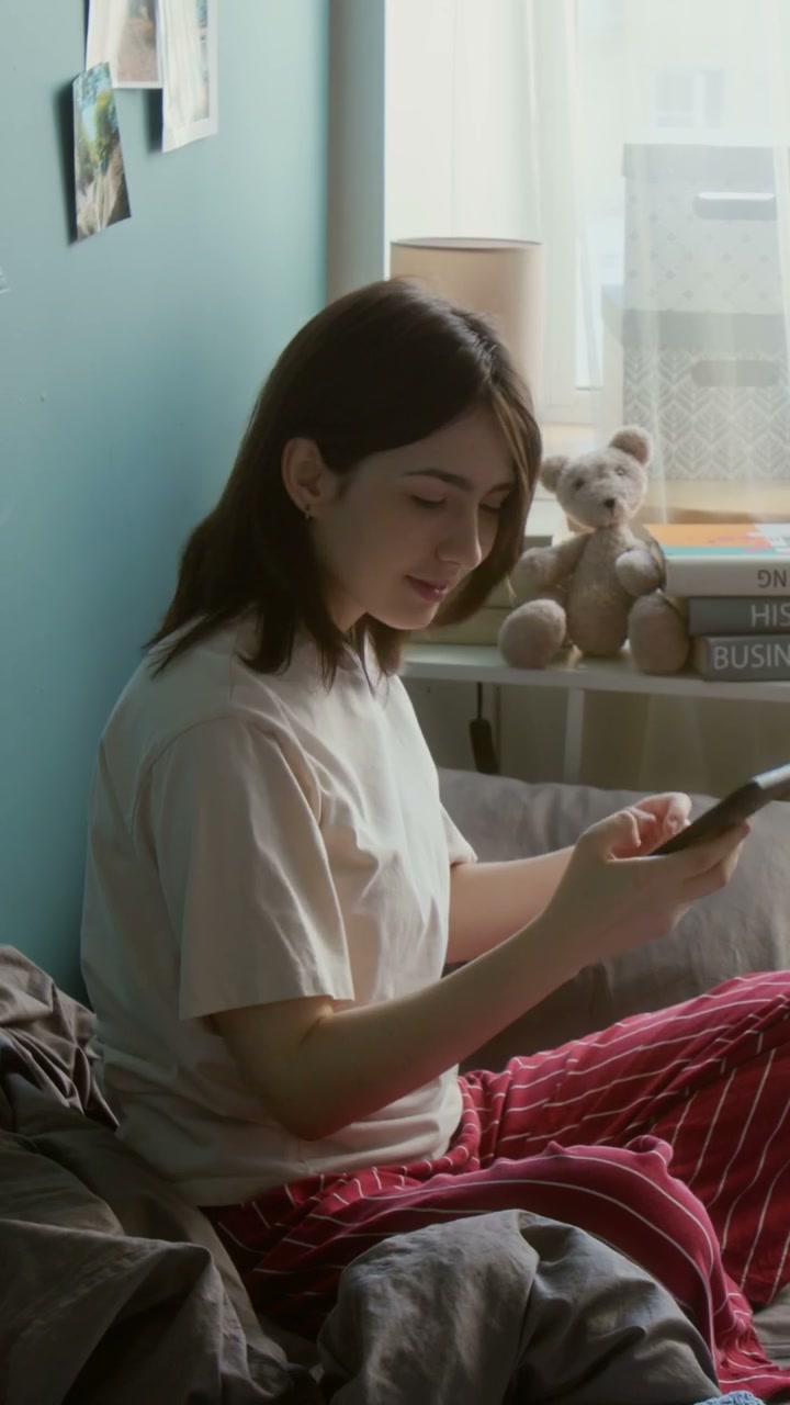 Young Woman Takes Selfie in Bedroom