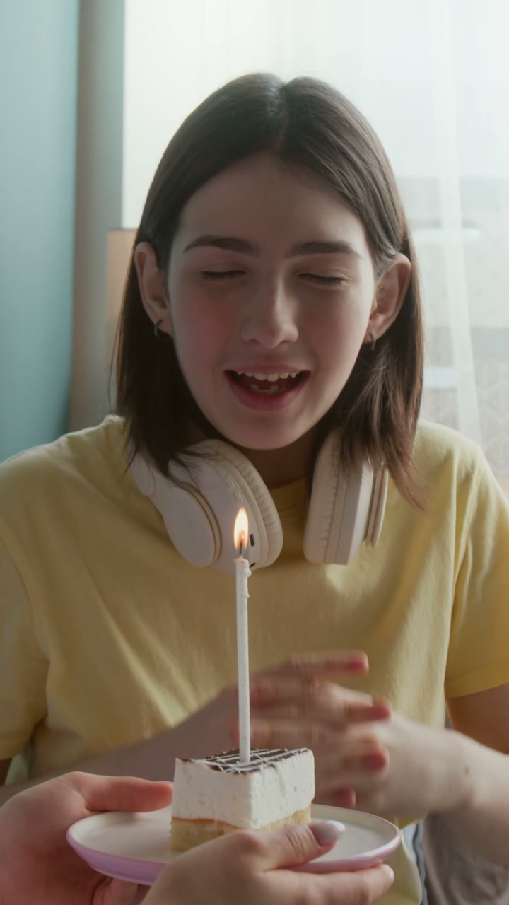 Young Woman Blowing Out Birthday Cake Candle