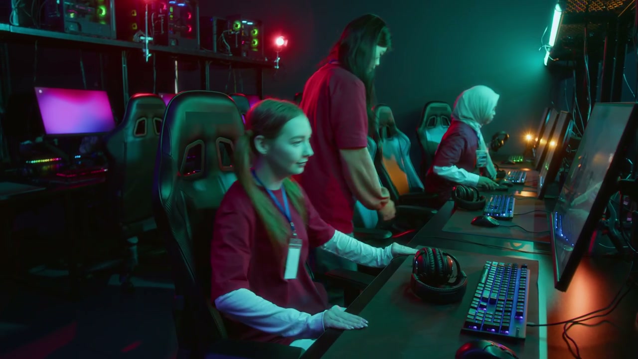 Diverse Girl Gamer Team Walking up to Computers and Sitting Down to Play