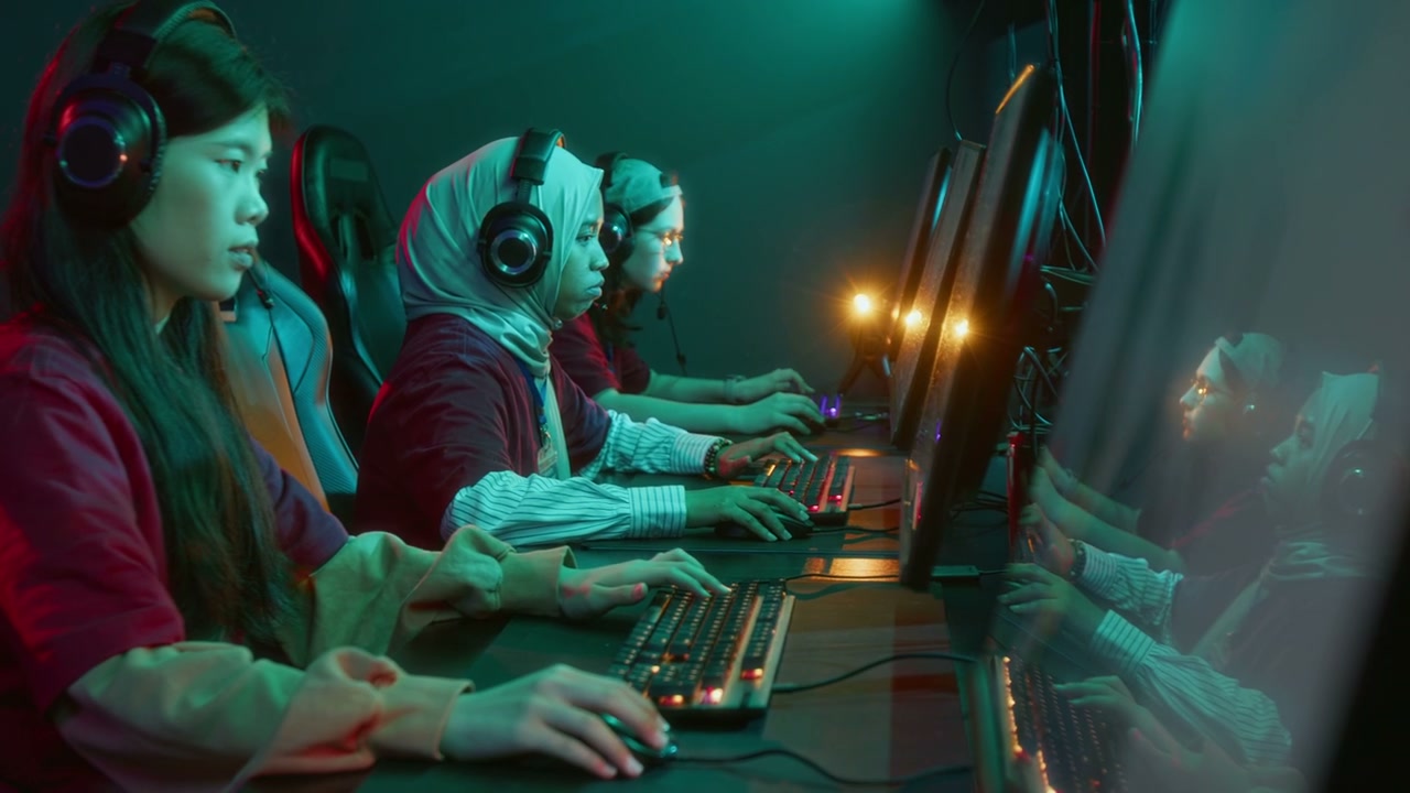 Focused Girl in Hijab and Headset Playing Online Shooter with Team in Club