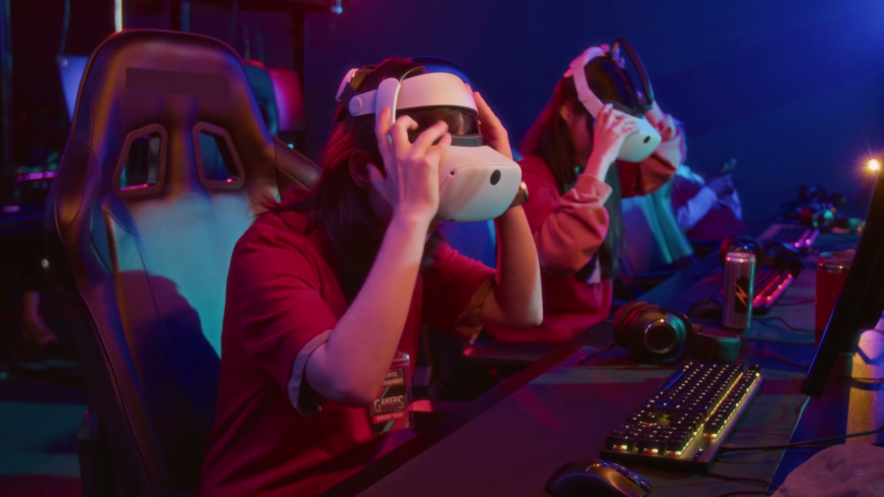 Two Female Gamers Putting on Virtual Reality Headsets in Cyberclub