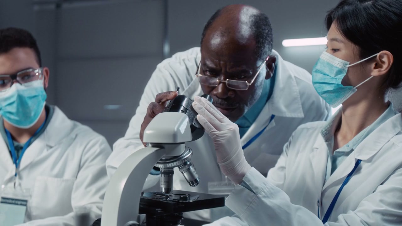 Scientists Using Microscope in Laboratory