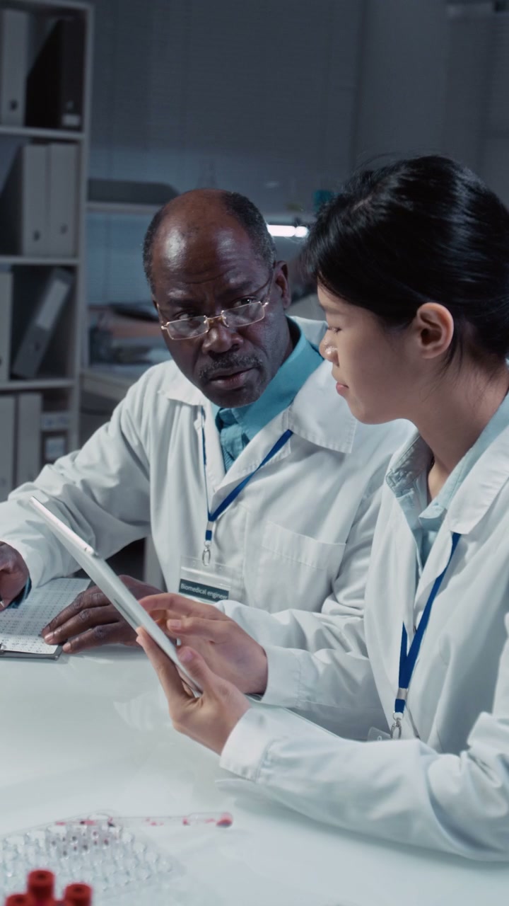 Scientists Discussing Research on Tablet
