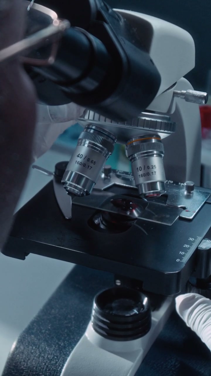 Researcher Adjusting Lab Microscope