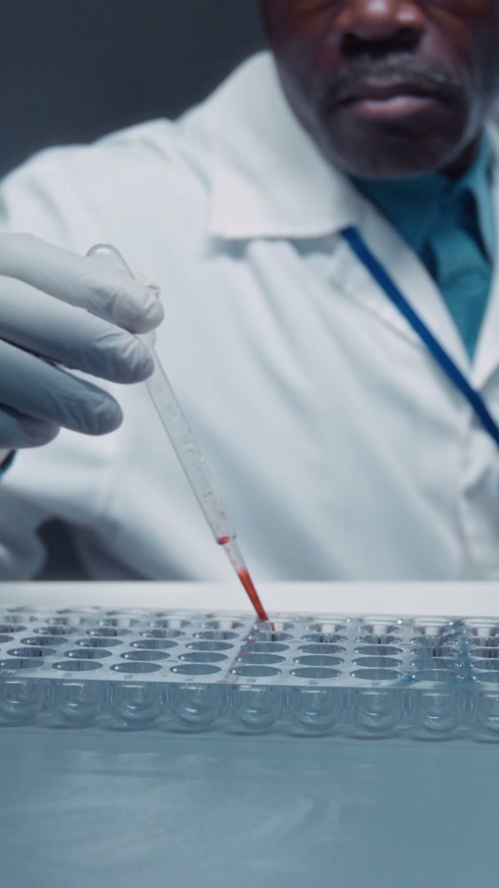 Scientist Pipetting Blood Samples in Lab