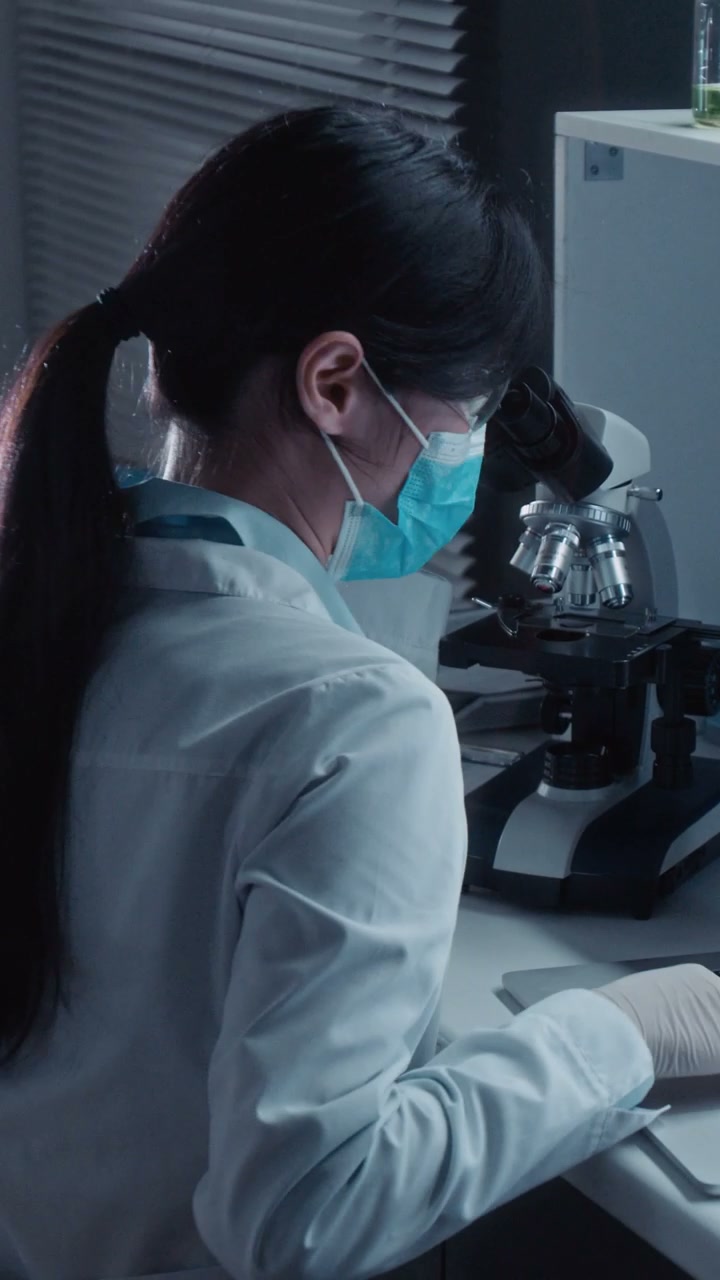 Scientist Working with Microscope in Lab