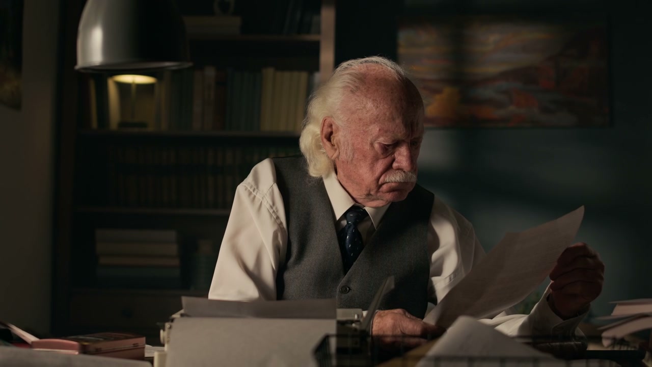 Pensive Senior Writer Reading at Desk