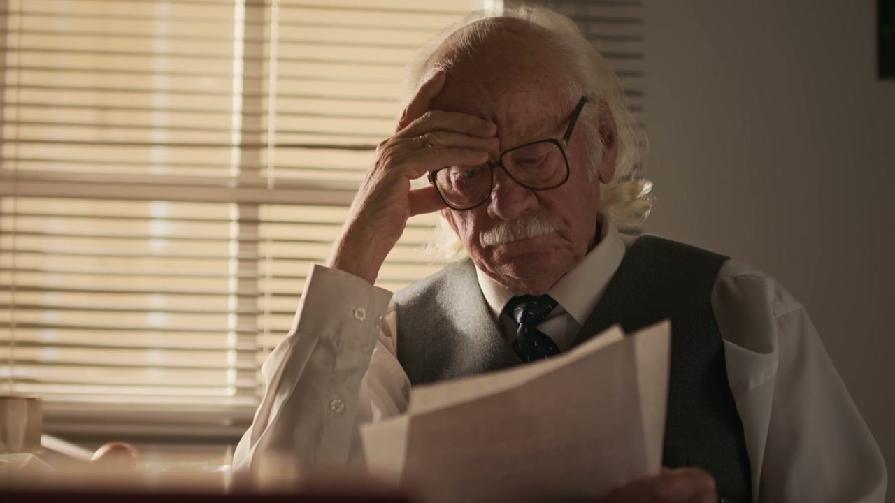Senior Writer Reading Documents in Study