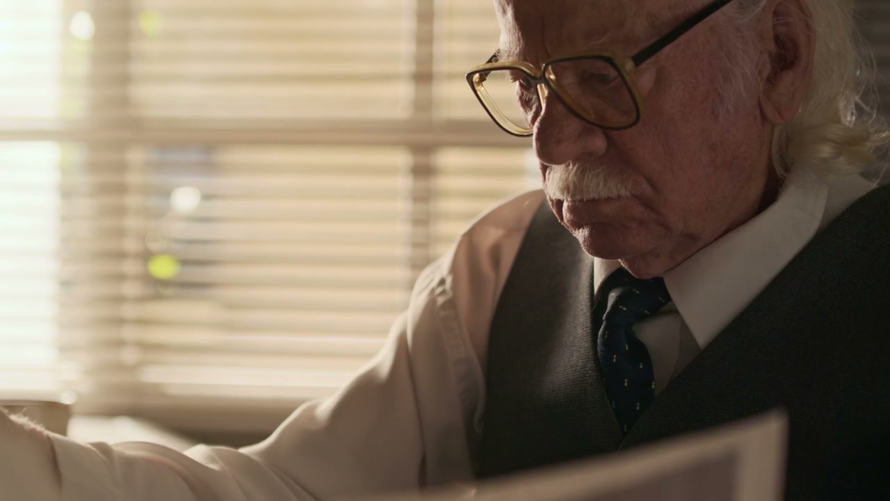 Senior Man Reading Papers in Office