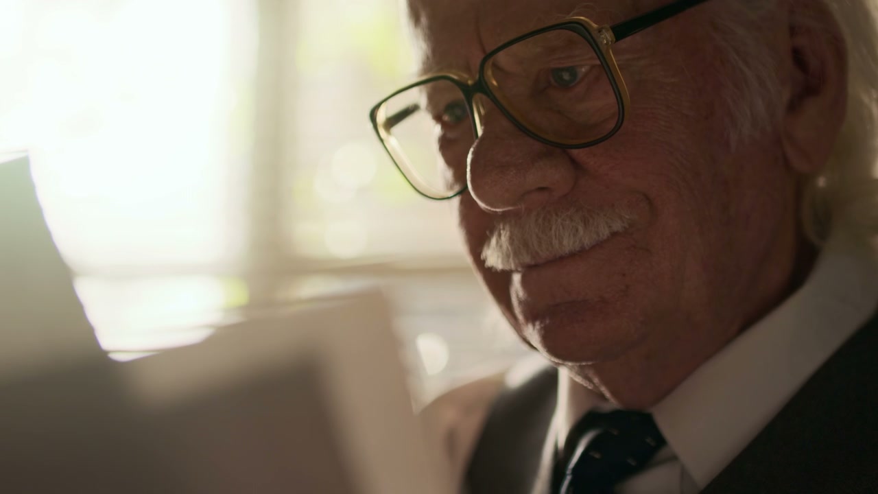 Elderly Man Reading Papers